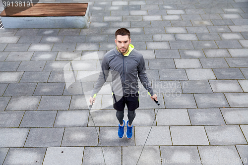 Image of man exercising with jump-rope outdoors