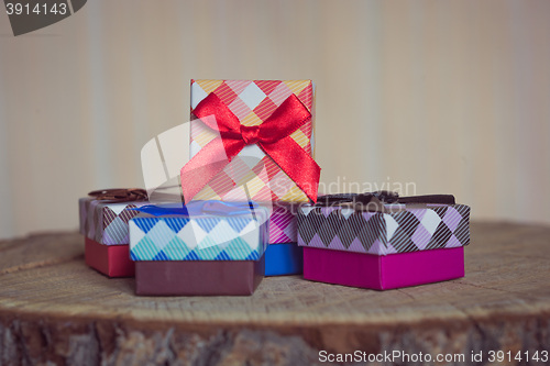 Image of Gift box with red bow on wood background