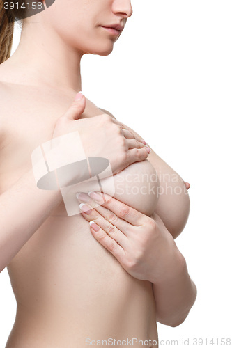 Image of Examining breasts. Close-up of young shirtless woman examining her breasts while. Isolated white background