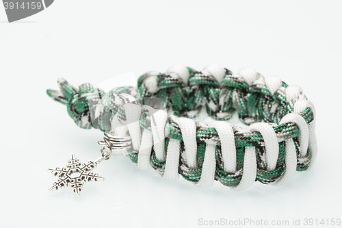 Image of green braided bracelet on white background. snowflake