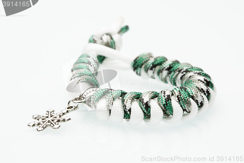 Image of green braided bracelet on white background. snowflake