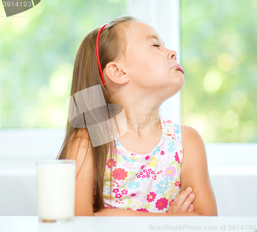 Image of Sad little girl with a glass of milk