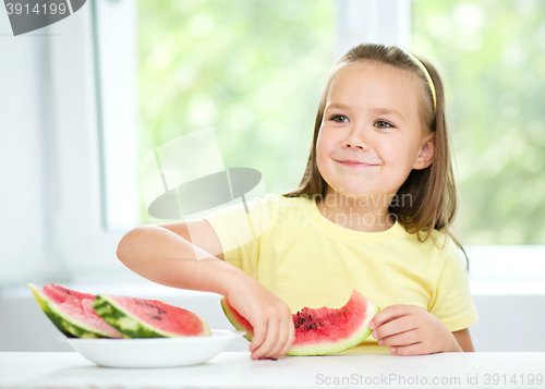 Image of Cute little girl is eating watermelon