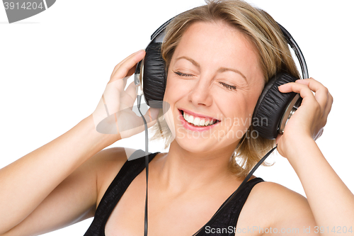 Image of Young woman enjoying music using headphones