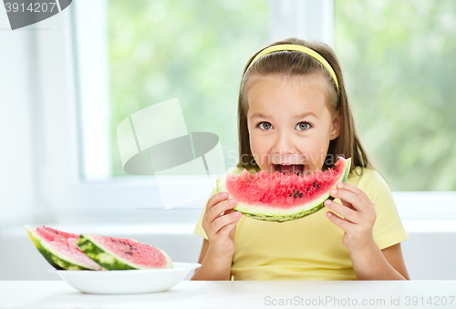 Image of Cute little girl is eating watermelon