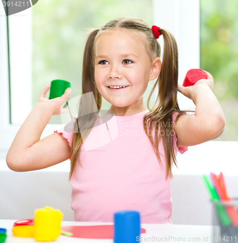 Image of Little girl is playing with plasticine