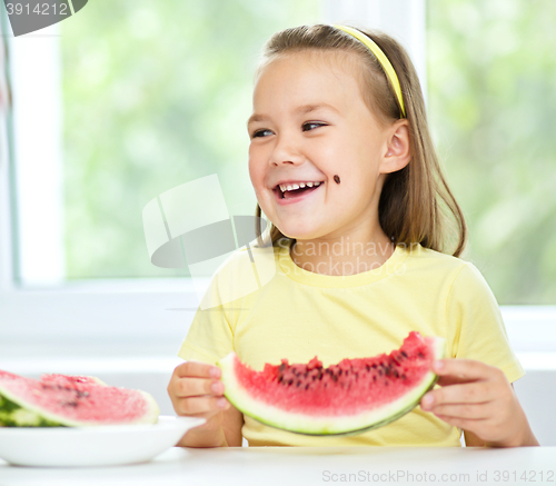 Image of Cute little girl is eating watermelon