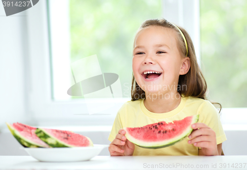 Image of Cute little girl is eating watermelon