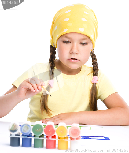 Image of Cute thoughtful child play with paints