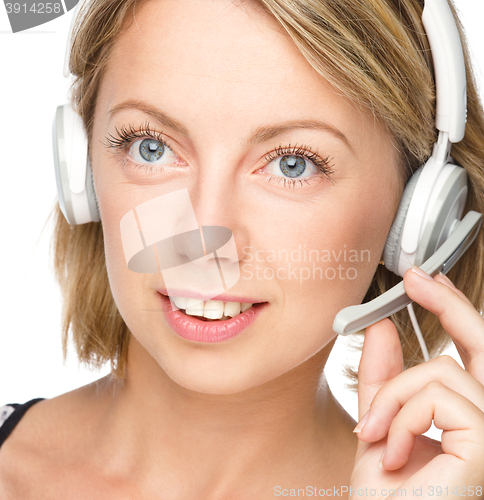 Image of Lovely young woman is talking to customers