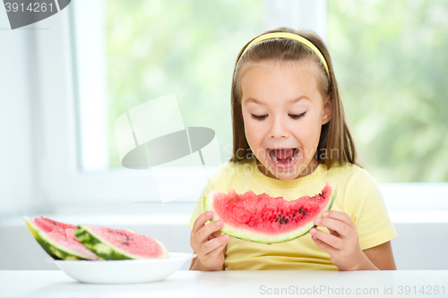 Image of Cute little girl is eating watermelon