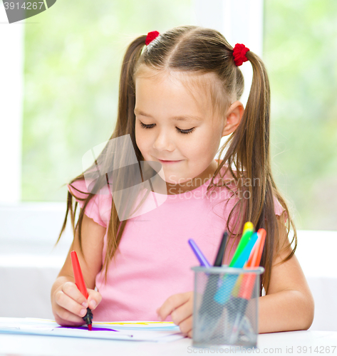 Image of Cute cheerful child drawing using felt-tip pen