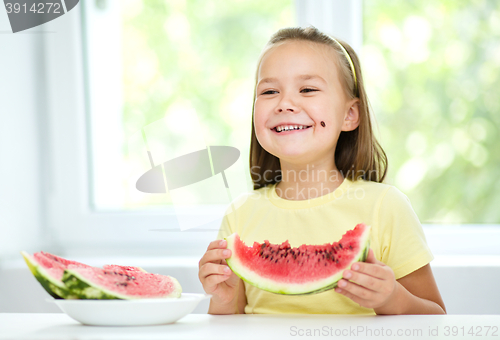 Image of Cute little girl is eating watermelon