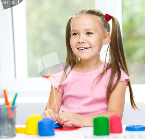 Image of Girl is having fun while playing with plasticine