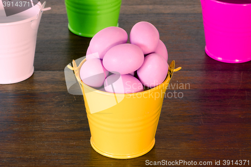 Image of Violet easter eggs in a yellow bucket