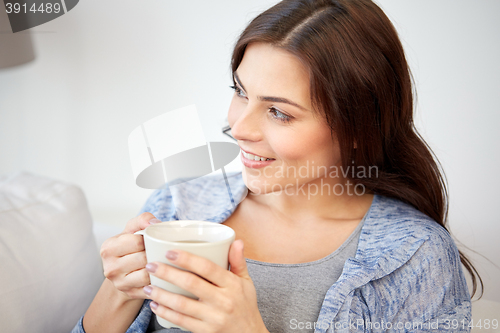 Image of happy woman with cup of tea or coffee at home