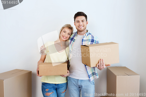 Image of smiling couple with big boxes moving to new home