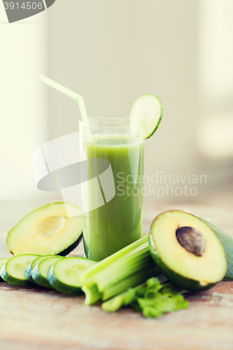 Image of close up of fresh green juice glass and vegetables