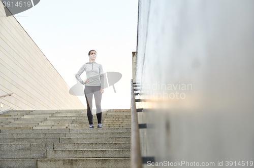 Image of sporty woman standing on in city stairs