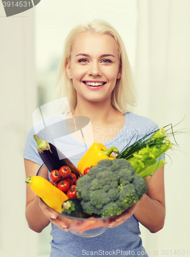 Image of smiling young woman with vegetables at home