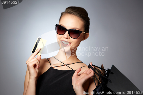 Image of happy woman with credit card and shopping bags