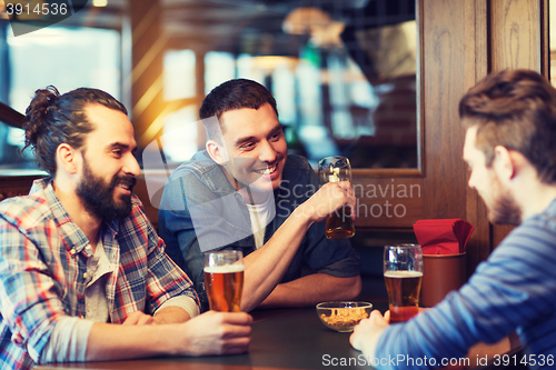 Image of happy male friends drinking beer at bar or pub