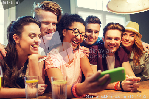 Image of happy friends with smartphone taking selfie at bar