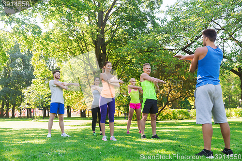 Image of group of friends or sportsmen exercising outdoors