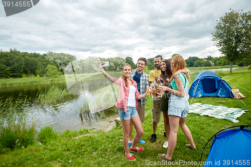 Image of happy friends taking selfie by smartphone at camp