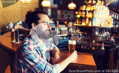 Image of happy man drinking beer at bar or pub