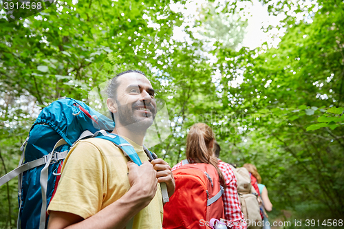 Image of group of smiling friends with backpacks hiking