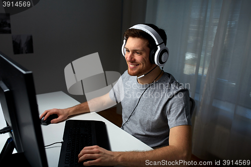 Image of man in headset playing computer video game at home