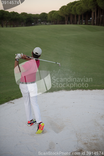 Image of golfer hitting a sand bunker shot on sunset