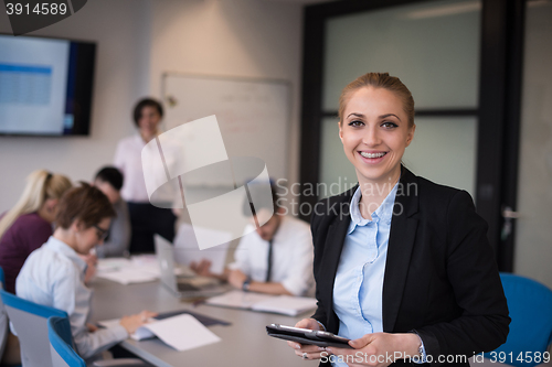 Image of business woman working on tablet at meeting room