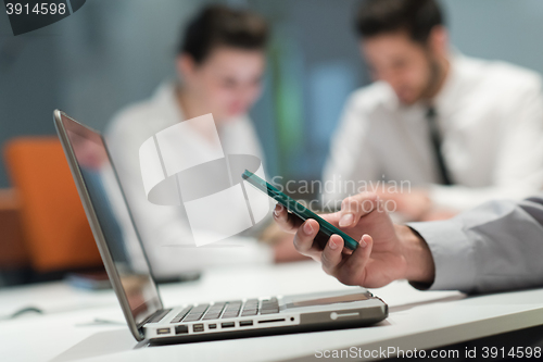 Image of close up of  businessman hands  using smart phone on meeting