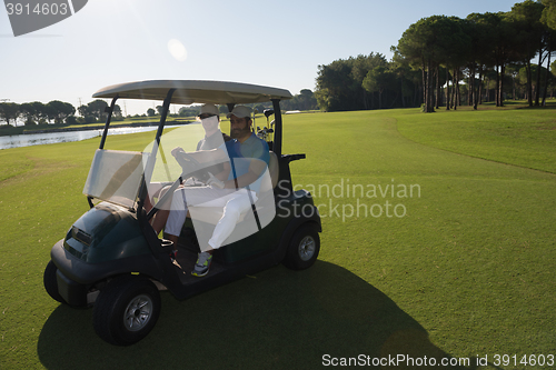 Image of golf players driving cart at course