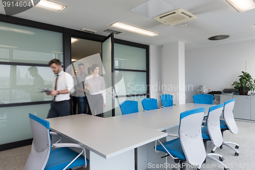 Image of business people group entering meeting room, motion blur