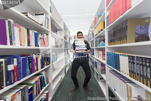 Image of Student holding lot of books in school library