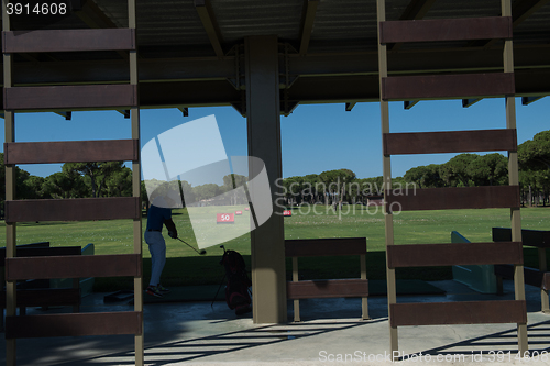 Image of golf player practicing shot on training