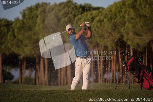 Image of golfer hitting a sand bunker shot on sunset