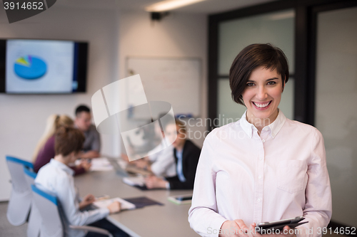 Image of hispanic businesswoman with tablet at meeting room