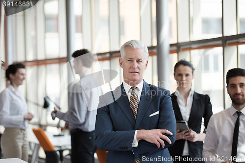 Image of portrait of senior businessman as leader  with group of people i