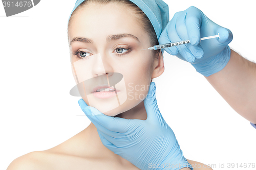 Image of Attractive woman at plastic surgery with syringe in her face