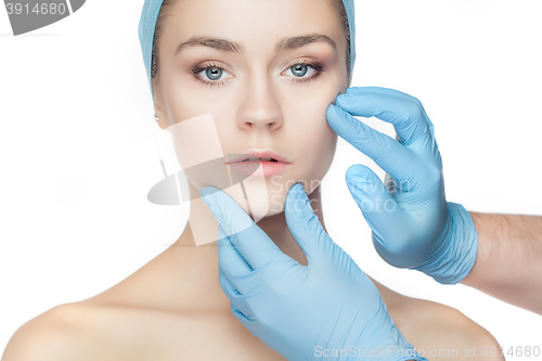 Image of Plastic surgery concept. Doctor hands in gloves touching woman face