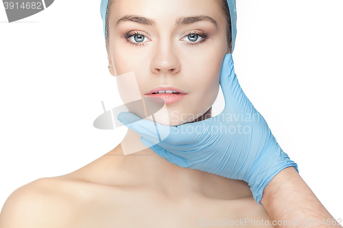 Image of Plastic surgery concept. Doctor hands in gloves touching woman face