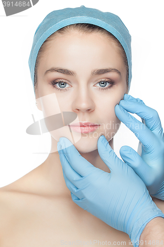 Image of Plastic surgery concept. Doctor hands in gloves touching woman face