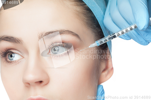 Image of Attractive woman at plastic surgery with syringe in her face