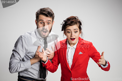 Image of The surprised business man and woman smiling on a gray background