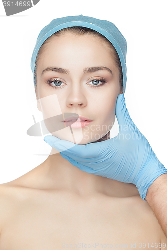 Image of Plastic surgery concept. Doctor hands in gloves touching woman face