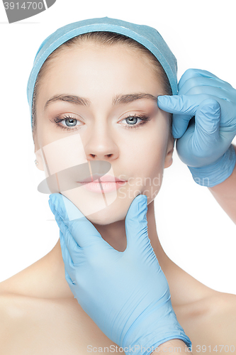 Image of Plastic surgery concept. Doctor hands in gloves touching woman face